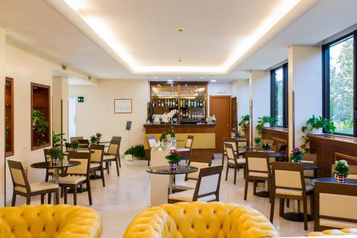 um restaurante com mesas e cadeiras e um bar em Hotel The Brand em Roma