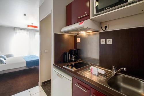 a kitchen with a sink and a counter top at Appart’City Confort Paris Villejuif in Villejuif