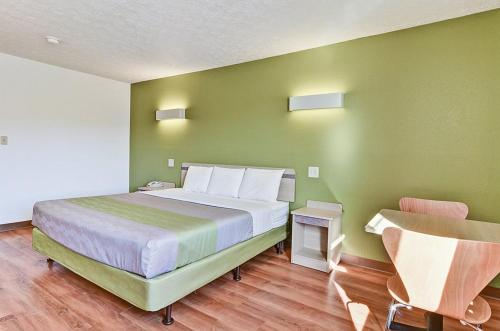a bedroom with a large bed with green walls at Economy Inn in Moon