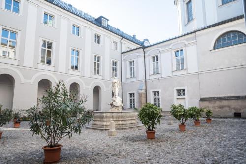 uma estátua no pátio de um edifício em Gästehaus im Priesterseminar Salzburg em Salzburgo