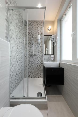 a bathroom with a shower and a sink at Downtown Boutique Hostel in Zadar