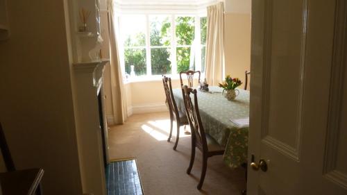 a dining room with a table and a window at Bijou B&B Lulworth in Lulworth Cove