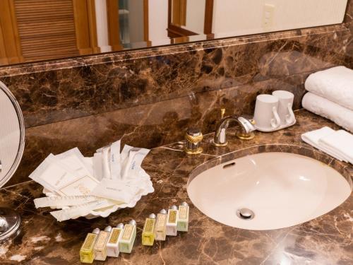a bathroom counter with a sink and a mirror at Keio Plaza Hotel Hachioji in Hachioji