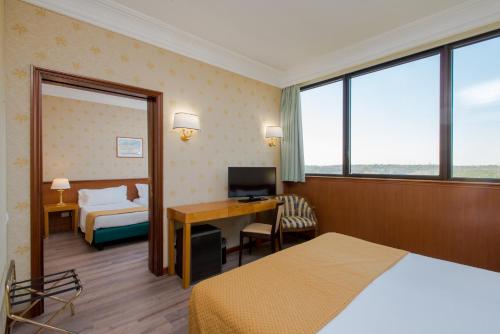 a hotel room with a bedroom with a bed and a desk at Hotel The Brand in Rome