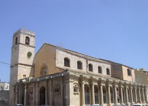 an old building with a tower and a church at Zenzero e Limone in Siracusa