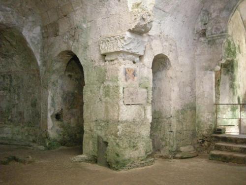 an old room with a stone wall and some stairs at Zenzero e Limone in Siracusa