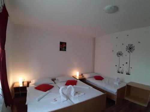 Cette chambre comprend 2 lits avec des oreillers rouges. dans l'établissement House Betty, à Grabovac