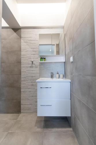 a bathroom with a white sink and a mirror at Akalli Studios in Ixia