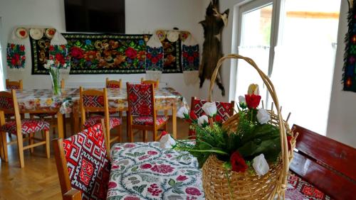 a dining room with a table and chairs with flowers on it at Casa Papițu in Vadu Izei