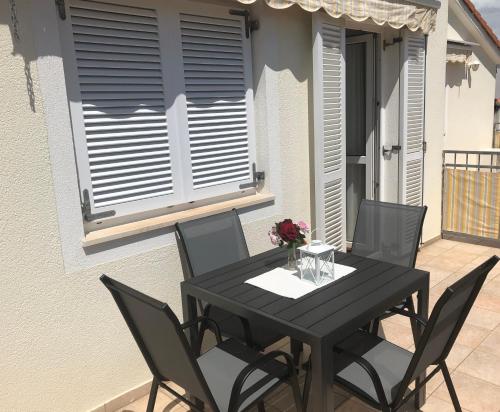 een zwarte tafel en stoelen op een patio bij Apartments Trogir in Trogir