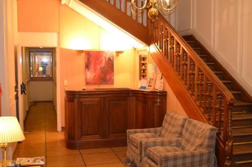 Hotel Gran Sarmiento في بوينس آيرس: غرفة معيشة بها درج وكرسيين