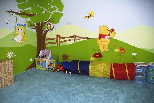 a childs room with a wall with winnie the pooh and a train at Apartmany A.Ša Kašperské Hory in Kašperské Hory