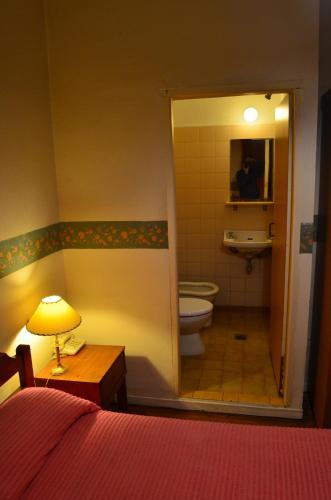 a bedroom with a bathroom with a toilet and a sink at Hotel Gran Sarmiento in Buenos Aires