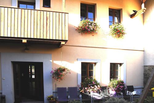 a building with chairs and flowers in front of it at Apartmany A.Ša Kašperské Hory in Kašperské Hory