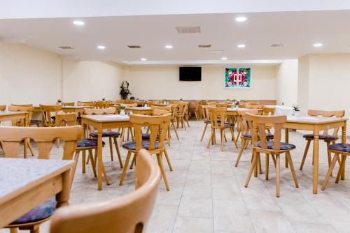 an empty restaurant with tables and chairs and a podium at Hotel und Campingstell und Zeltplatz an der Talsperre im Harz in Altenbrak