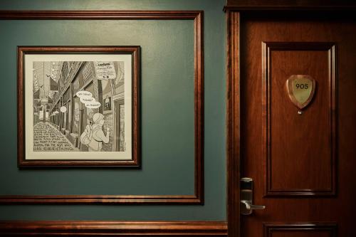 a picture hanging on a wall next to a door at Graduate by Hilton Ann Arbor in Ann Arbor
