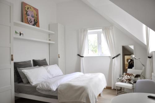 a white bedroom with a bed and a window at The Acorns in Marlow
