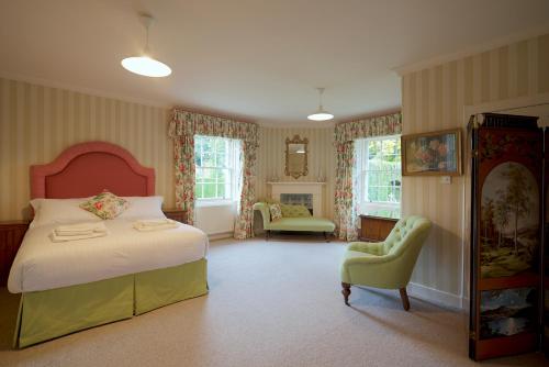 a bedroom with a bed and a chair at Glamis House in Forfar