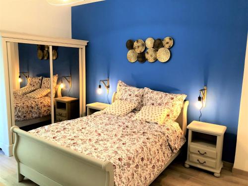 une chambre avec un lit et un mur bleu dans l'établissement BEAU T3 NEUF PROCHE VIEUX-PORT A LA PLACE CORDERIE, à Marseille