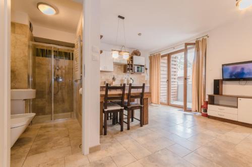 a kitchen and dining room with a table and a bathroom at APARTAMENTY MIERZEJA - BALTIC PARK STEGNA, 33m2-57m2, 500 m od plaży, Bezpłatny Meleks in Stegna