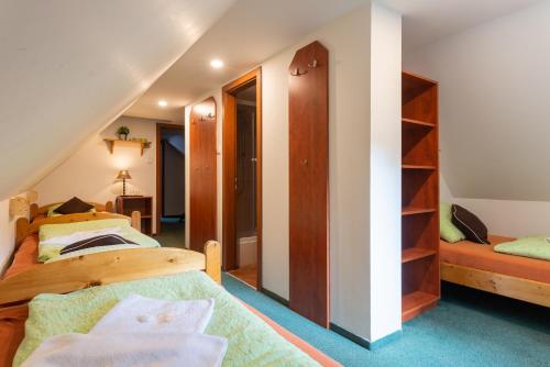 a attic bedroom with two beds and a staircase at Svycarska Bouda in Špindlerův Mlýn