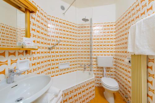 a bathroom with a sink and a toilet at Park Hotel Faloria in Canazei