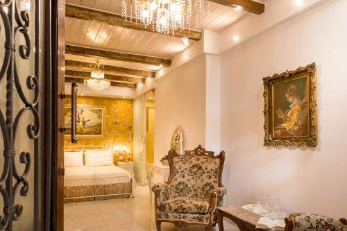 Un dormitorio con una cama, una silla y una lámpara de araña. en Hamam Suites Portou, en La Canea