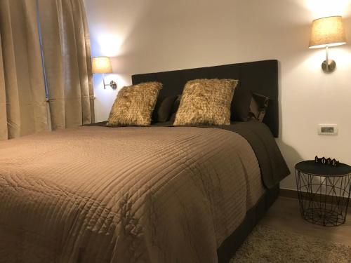 een slaapkamer met een groot bed met 2 kussens bij Ultra in Lovran