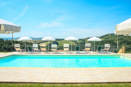 a swimming pool with chairs and umbrellas at Colle Bertini in Montaione