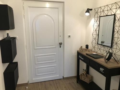 Una puerta blanca en una habitación con escritorio y espejo. en Ultra, en Lovran