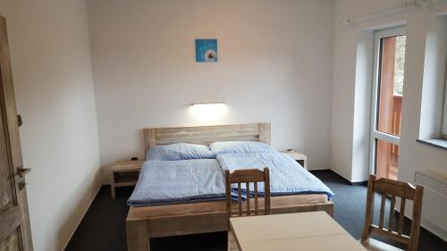 クボヴァ・フチにあるPension Pekのベッドルーム1室(ベッド2台、テーブル、椅子付)