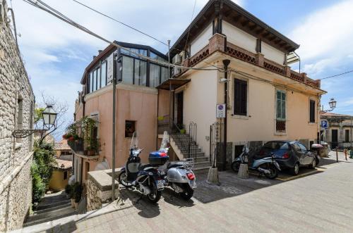 
two motorcycles parked in front of a building at Sweet Taormina Apartment in Taormina
