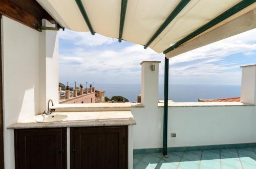 Sweet Taormina Apartment في تاورمينا: حمام مع حوض وإطلالة على المحيط