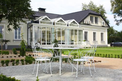 a table and chairs in front of a house at Hotel&SPA Dwór Droblin in Leśna Podlaska