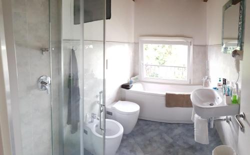 a bathroom with a tub and a toilet and a sink at Cherry House B&B in Polinago
