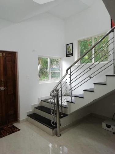 a staircase in a home with white walls at Nandana's Residency Munnar - A 4BHK Homestay for Indian Families in Munnar
