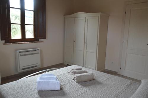 Un dormitorio con una cama con toallas. en Le Bozze "Il Leccino" con piscina, WI-FI, posto auto, en Castagneto Carducci