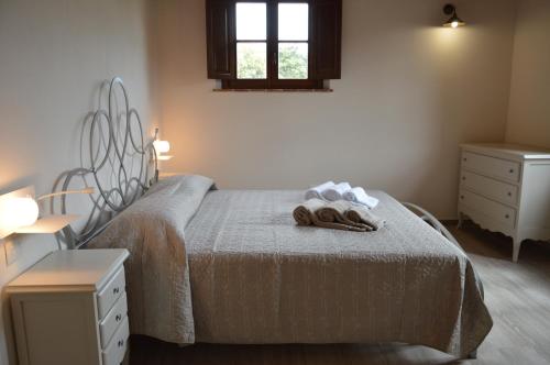 ein Schlafzimmer mit einem Bett mit zwei Handtüchern darauf in der Unterkunft Le Bozze "Il Leccino" con piscina, WI-FI, posto auto in Castagneto Carducci