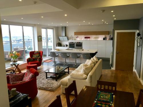 a living room with a couch and a kitchen at Hillrise B&B in Portrush