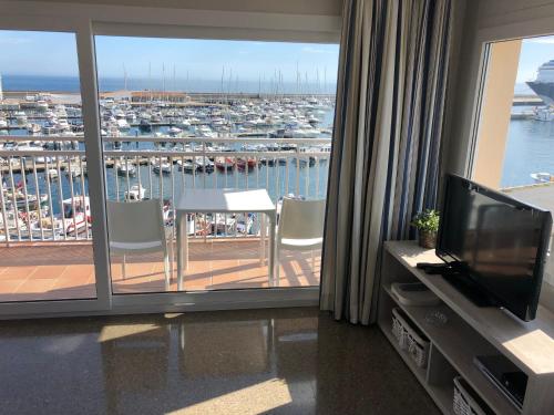 a room with a balcony with a view of a harbor at Apartaments la Catifa in Palamós