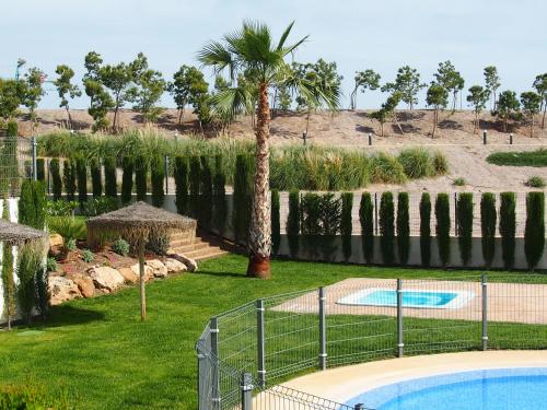 un patio con una piscina y una palmera en Las Azaleas, en San Juan de los Terreros