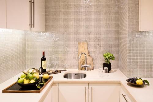 eine Küche mit einem Waschbecken und einer Flasche Wein in der Unterkunft No.5 Maddox Street in London