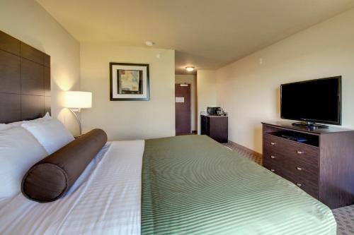 a hotel room with a bed and a flat screen tv at Cobblestone Inn & Suites - Brillion in Brillion