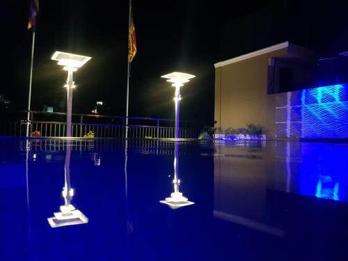 two street lights in a parking lot at night at Pinnacle boutique villas in Galle