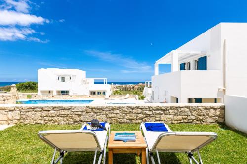 einen Tisch und Stühle vor einer Villa in der Unterkunft Triton Sea View Villa in Georgioupoli