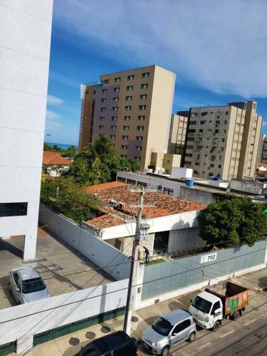 a parking lot with cars parked in front of buildings at Pousada Catamarã Praia de Pajuçara in Maceió
