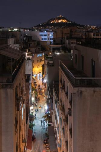 a city street at night with a mountain in the background at ATHENS STORIES in Athens