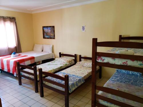 a room with three bunk beds in a room at Pousada Catamarã Praia de Pajuçara in Maceió