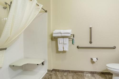 a bathroom with a toilet and a shower with towels at Cobblestone Inn & Suites - Brillion in Brillion