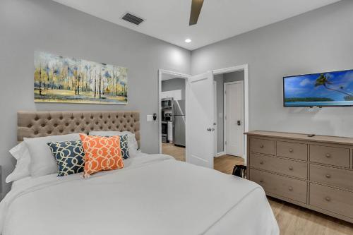 ein Schlafzimmer mit einem Bett, einer Kommode und einem TV in der Unterkunft New 1/1 :Loft Minutes From Heart of Tampa -Unit C in Tampa